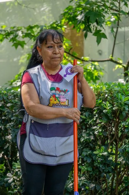 Cleaner using a vacuum in a stylish indoor setting, showcasing cleaning equipment and techniques.